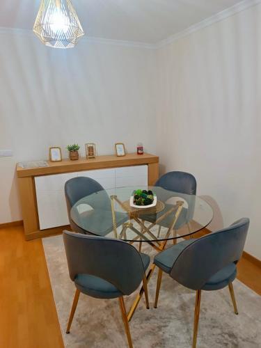 a dining room with a glass table and chairs at Prestige Solmar - Sea View Apartment - Free covered parking - Caniço Center in Caniço