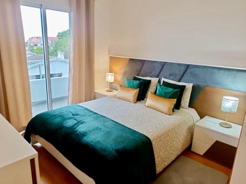 a bedroom with a large bed with a large window at Prestige Solmar - Sea View Apartment - Free covered parking - Caniço Center in Caniço