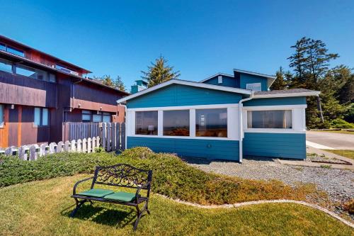 a bench sitting in the grass in front of a house at Pacific Princess in Crescent City