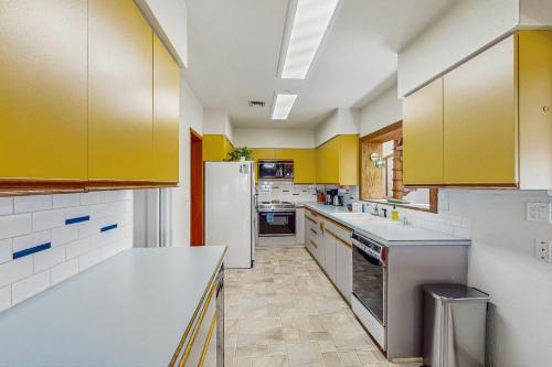 a kitchen with yellow cabinets and a white refrigerator at Pacific Princess in Crescent City