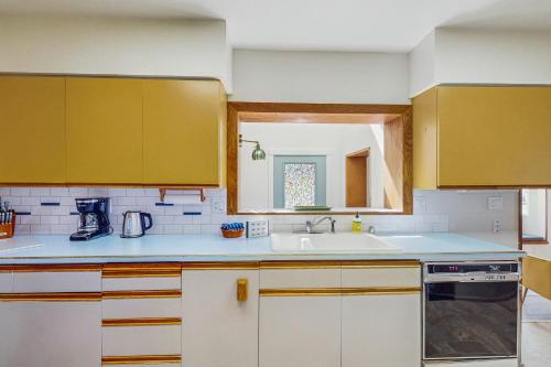 a kitchen with yellow cabinets and a sink at Pacific Princess in Crescent City