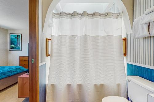 a white shower curtain in a bathroom with a bed at Pacific Princess in Crescent City