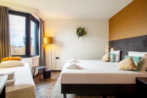 a hotel room with two beds and a window at Hotel Lowietje Lisse - Keukenhof in Lisse