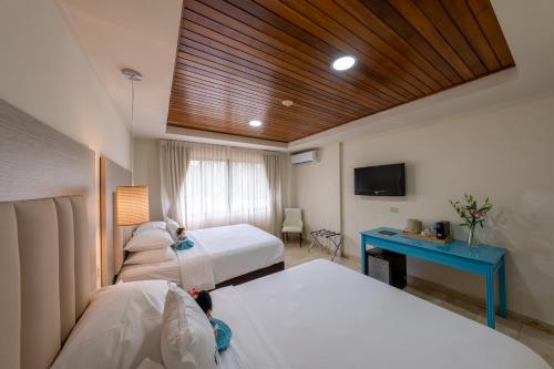 a hotel room with two beds and a blue desk at Hotel Faranda Guayacanes, a member of Radisson Individuals in Chitré