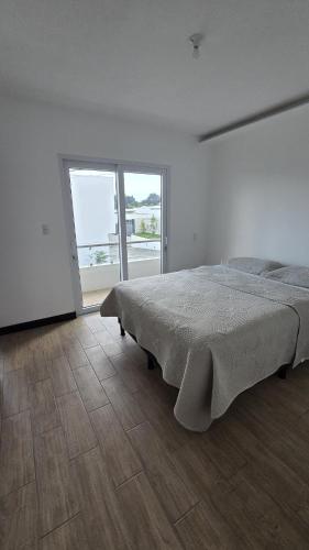 a white bedroom with a bed and a large window at Relaxation House 