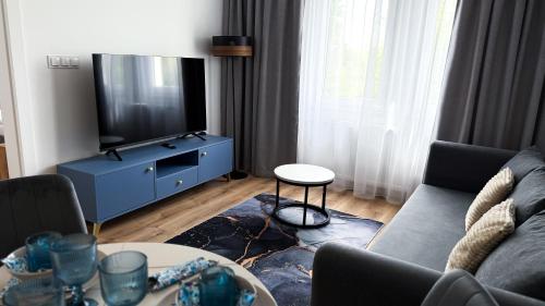 a living room with a couch and a tv at Apartamenty Piast Myślibórz in Myślibórz