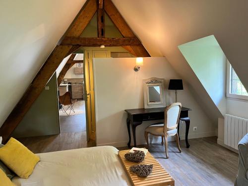 Cette chambre mansardée comprend un lit et un bureau. dans l'établissement Le Loft by Le Petit Pressoir, à Saint-Gatien-des-Bois