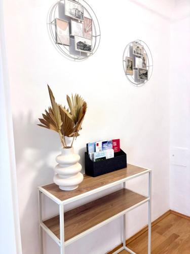 a console table with a vase and two mirrors at Franziskaner Suites #13 in Graz