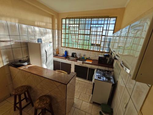 a small kitchen with a refrigerator and a sink at Residencial Samara in Rondonópolis