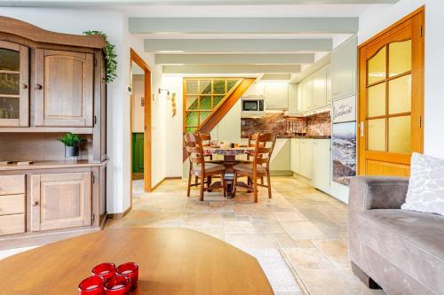 a kitchen and living room with a table and a couch at Huisje Marie Loosdrecht in Loosdrecht