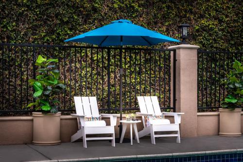 two chairs and a table with a blue umbrella at Alpine Inn near Convention Center and the Park in Anaheim