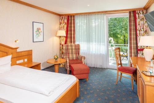 a hotel room with a bed and a window at Parkhotel an der Therme in Bad Krozingen