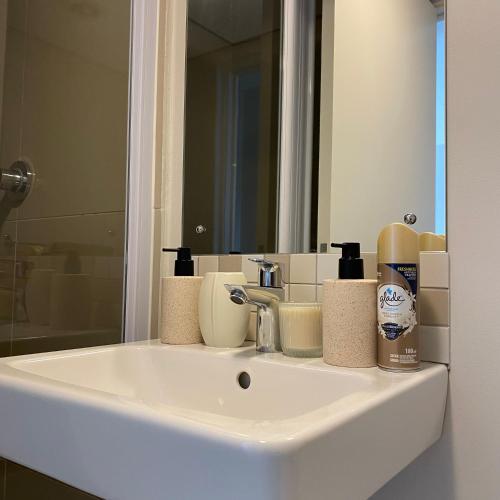 a white bathroom sink with a mirror and a sink at Casa Vita Umhlanga in Durban