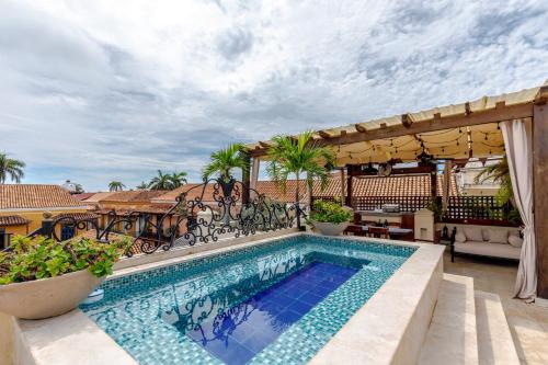 einen Außenpool mit einer Pergola in der Unterkunft Estrella de San Pedro B&B in Cartagena de Indias