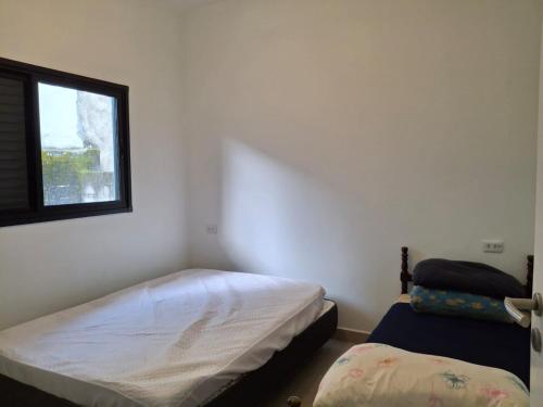 a bedroom with two beds and a window at Casa aconchegante 300mts da praia in São Sebastião