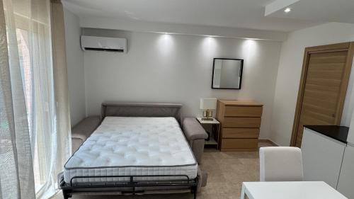 - une petite chambre avec un lit et une commode dans l'établissement Studio RDJ Piscine Parking, à Mougins