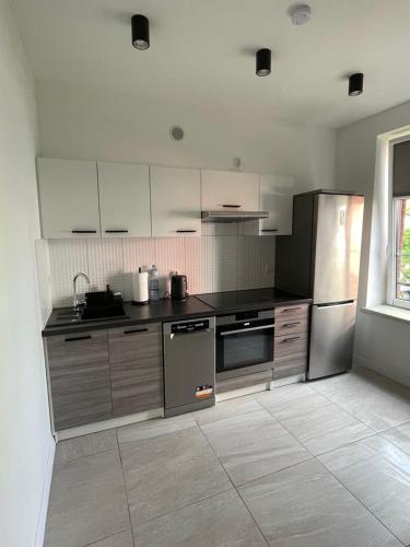a kitchen with stainless steel appliances and a window at Apartament 4 Wolności in Brzeg