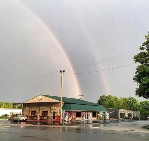 a rainbow in the sky over a building at Still Waters Tiny Home in Tracy City