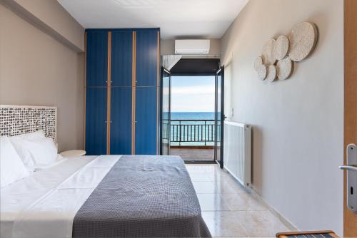 a bedroom with a bed and a view of the ocean at Flat on the sea in Póros Kefalonias