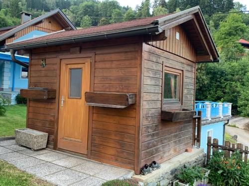 a wooden shed with a door on a yard at Haus Ernestine in Sankt Urban