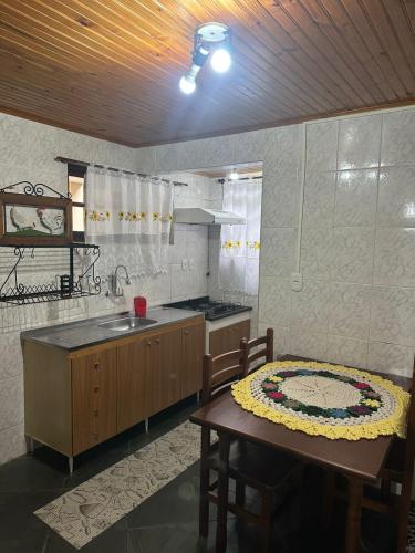 a kitchen with a table and a sink and a table and a tableasteryastery at Casa Quina da mata in Santo Antônio do Pinhal