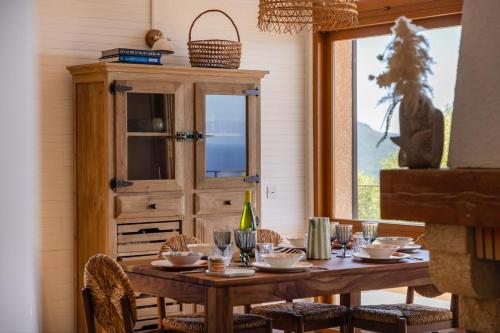 a dining room with a table and a cabinet at Signura, maison entre mer et maquis in Piana