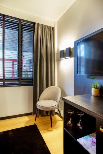 a living room with a chair and a television at Hotel Lowietje Lisse - Keukenhof in Lisse