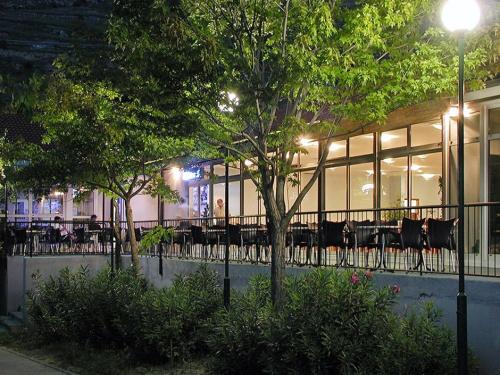 a restaurant with tables and chairs in front of a building at Mala Luka - Omiš, Beach Resort in Stanići
