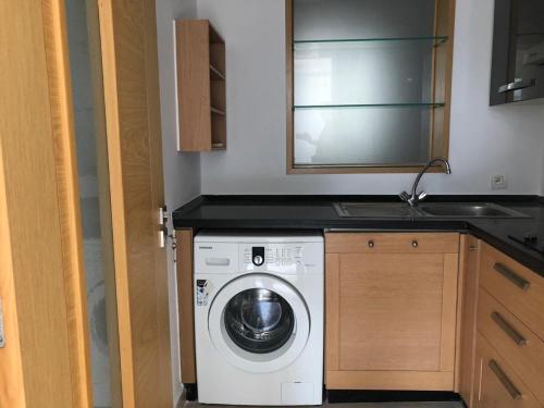 a kitchen with a washing machine and a sink at Brise de Tamaris in Oulad Akkou