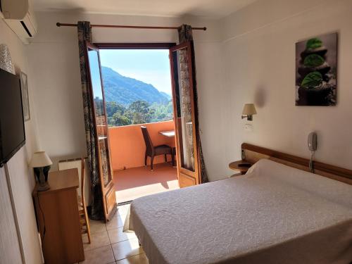 - une chambre avec un lit et une porte donnant sur un balcon dans l'établissement Appartement le porto, à La Celle-sous-Gouzon