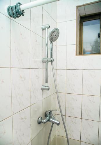 a shower with a shower head in a bathroom at MBEYA PARADISE INN in Mbeya