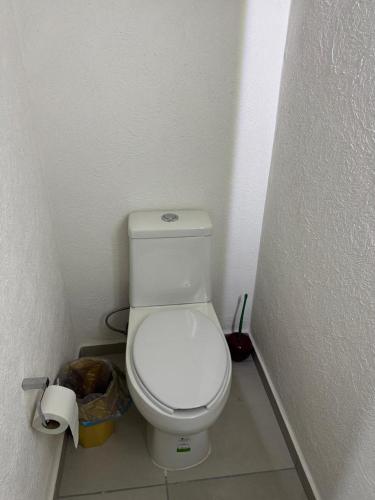 a bathroom with a white toilet in a stall at Todo lo que necesitas Adamar! in Tlajomulco de Zúñiga