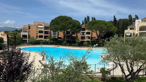 une grande piscine bleue avec des bâtiments en arrière-plan dans l'établissement Studio RDJ Piscine Parking, à Mougins