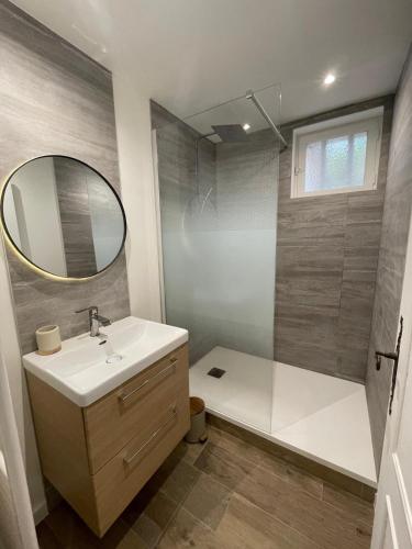 une salle de bain avec un lavabo et une douche avec un miroir dans l'établissement La maison de Marinette, à Séguret