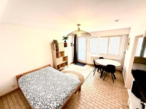 une petite pièce avec un lit et une table dans l'établissement Appartement proche Strasbourg Centre 7 min gare, à Strasbourg