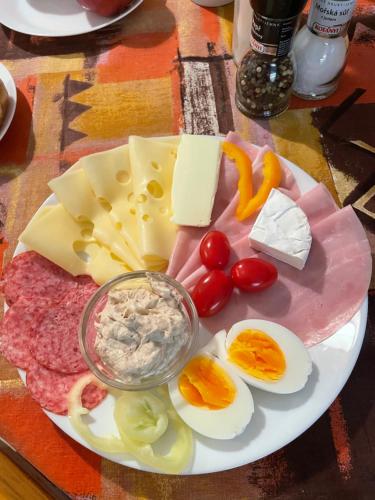 a plate of food with eggs meats and cheese at Penzion Motylek in Vřesina