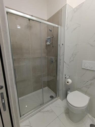 a bathroom with a glass shower with a toilet at Le follie in Maddaloni
