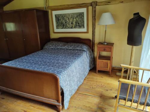 a bedroom with a bed with a blue comforter at Cabaña de troncos en el bosque in San Carlos de Bariloche