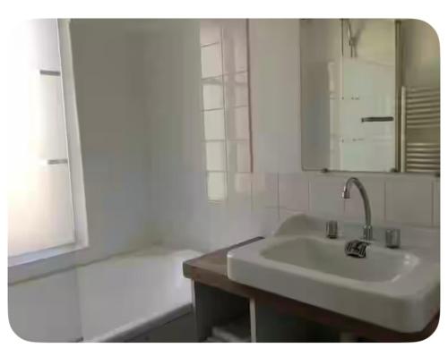 a white bathroom with a sink and a bath tub at Charmante maison de pêcheur Etretat in Étretat