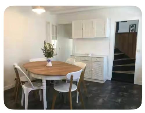 a kitchen with a wooden table and chairs and a staircase at Charmante maison de pêcheur Etretat in Étretat