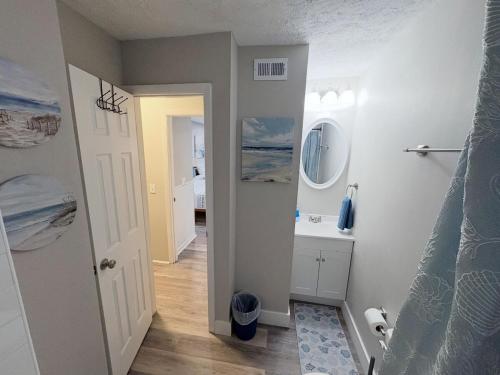 a bathroom with a sink and a toilet and a mirror at Renovated OC Condo Walk to Beach Pool & Park in Ocean City