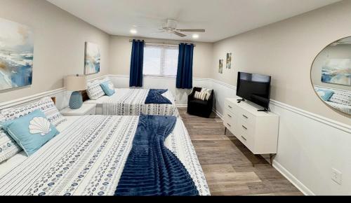 a bedroom with two beds and a flat screen tv at Renovated OC Condo Walk to Beach Pool & Park in Ocean City