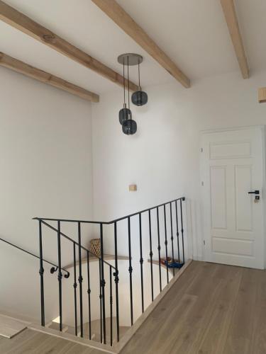 a staircase with black railings in a white room with a door at Dworek Pod Wierzbami 