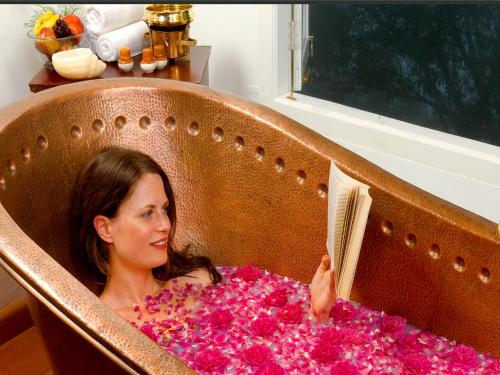 a woman reading a book in a chair filled with flowers at Blackberry Hills Munnar Nature Resort & Spa in Munnar