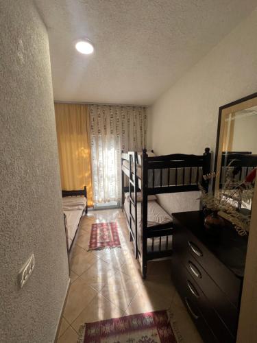 a small room with two bunk beds and a mirror at Hotel PEJA in Velipojë