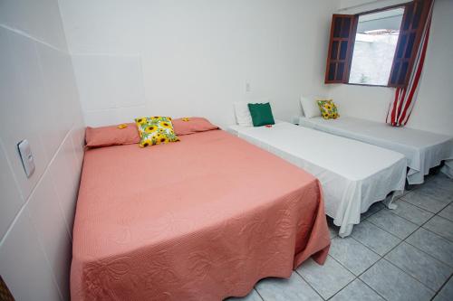 a room with two beds and a couch at Pousada dos Girassois Trancoso in Porto Seguro