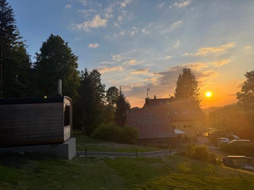 a sunset over a building with the sun in the sky at Penzion na Lůkách in Horní Bečva