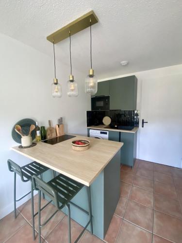 une cuisine avec un îlot et un comptoir dans l'établissement Mazet vue mer et piscine chauffée, au Lavandou