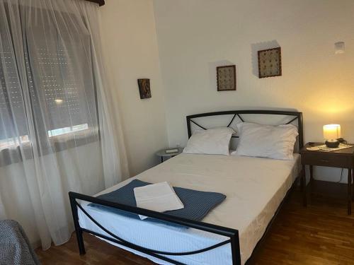 a bedroom with a bed and a window with a lamp at Second Home Ierissos in Ierissos