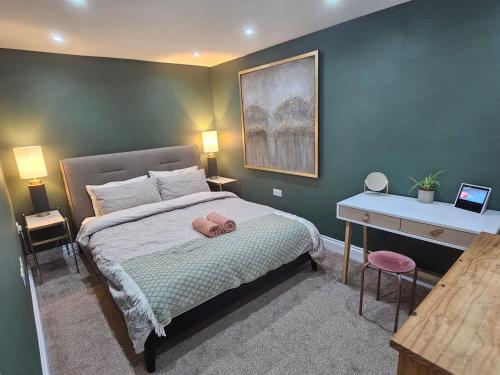 a bedroom with a bed with a pink towel on it at StayZen Apartments - Private Garden & Free Parking Ground Floor Central Woking - Business & Leisure in Woking